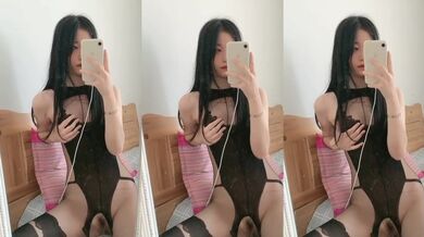 セクシーなジャンプスーツを着た女の子が鏡の前で胸を掴む