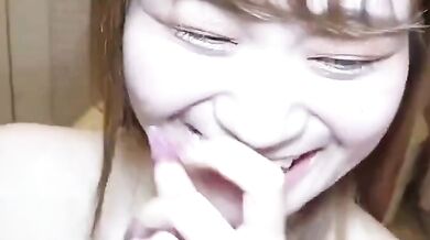 Sucking on a breast and smiling happily