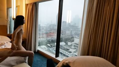 カップルは窓の外の美しい景色を眺めながらホテルの部屋でセックスをした