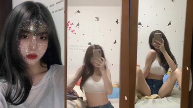 Cô gái gợi cảm với bộ ngực nhỏ và hình xăm nhìn vào gương