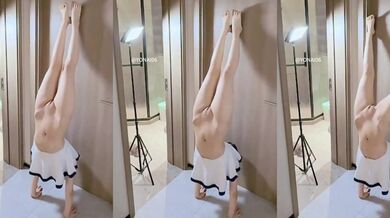 Girl in sailor suit with ponytails doing handstand